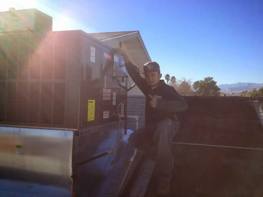 HVAC technician performing HVAC Inspection on a rooftop unit in Brookline